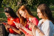 junge-frauen-auf-parkbank-mit-smartphone junge-frauen-auf-parkbank-mit-smartphone